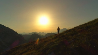 空中剪影 女人攀登山顶，举起双臂取胜的轮廓