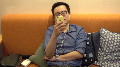   年轻的亚洲商人通过智能手机与朋友交谈FaceTime