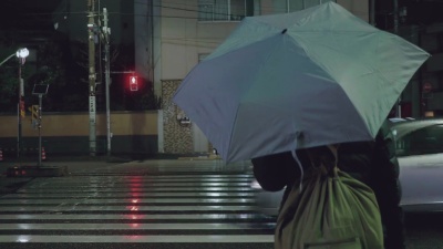 城市街道上撑伞人的后视图
