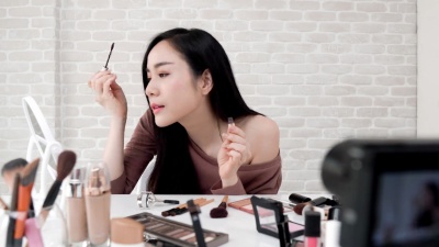 年轻的亚洲女子美女录像机录音化妆教程