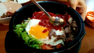 在加热的石碗中搅拌bibimbap，韩国菜