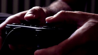男性手中的电子游戏控制台控制器