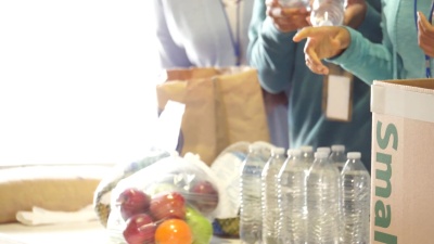 一队难以辨认的志愿者在食物银行组织捐赠的食品