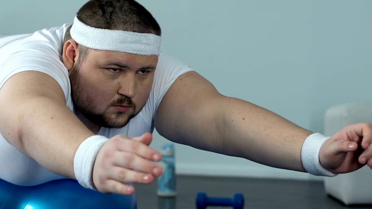 肥胖男子在家锻炼后放松健身球复杂，力量和耐力