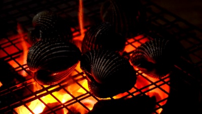 在亚洲夜市上用红火烧烤海鲜的过程的特写