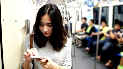 年轻漂亮的女孩使用智能手机