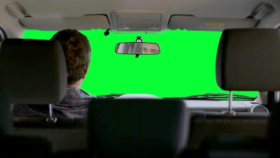 一个男人在绿色的背景下开车