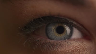 特写滑动镜头的一个女人的蓝色眼睛从前面轻一天化妆。