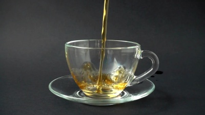 把茶倒进杯子里。慢动作。