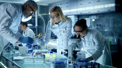 医学研究科学家团队致力于新一代疾病的治疗。他们使用显微镜，试管，微量吸管和写下分析结果。实验室看起来忙碌，明亮和现代。
