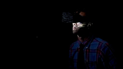 年轻商人在家中黑暗中戴着虚拟现实技术眼镜玩迷宫游戏