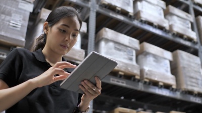在仓库中使用Tablet PC的手工工人，特写镜头