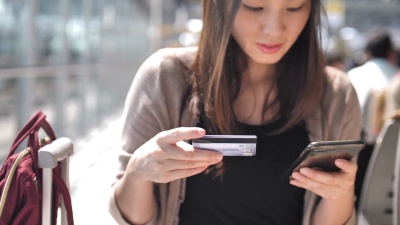 年轻女子用信用卡在智能手机上购物