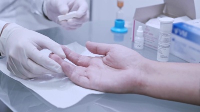 手指血液测试。医生在做血液分析。医生手使用柳叶刀