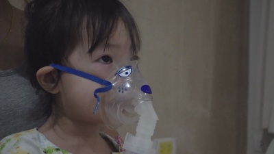 一个小亚洲女孩在医院用喷雾器进行药物吸入治疗。