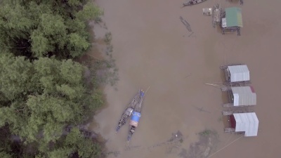 空中垂直拍摄，俯瞰被暴雨淹没的河岸上漂浮的房屋