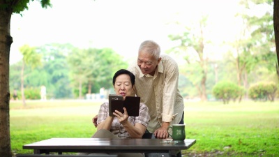 使用PAD进行数字通信的亚洲老人笑