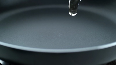 将油倒入煎锅，慢动作