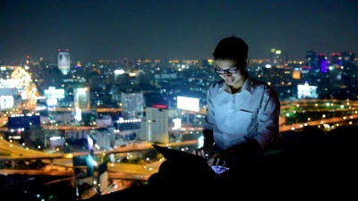 在Skyscaper背景下使用笔记本电脑和数字平板电脑的业务