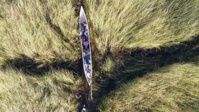 沿着奥卡万戈三角洲的水道径直向下空中放大游客的Mokoro狩猎之旅的视图