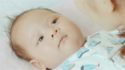 母亲亲吻她的混血儿的脸颊可爱的新生小女婴