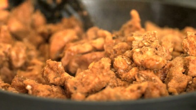 油炸切碎的鸡肉块的过程。特写