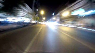 POV观点骑摩托车沿夜间亚洲道路交通。延时摄影。泰国，芭堤雅