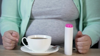 肥胖女士用甜味剂代替糖，放进茶里，糖尿病