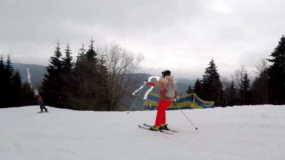 滑雪者和滑雪者沿着滑雪坡下坡。