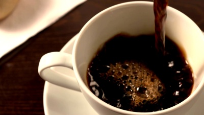 用茶托将黑咖啡倒入杯中
