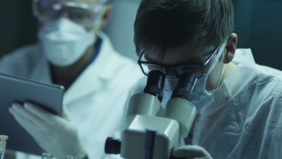 一组科学家正在进行生物学研究，并将数据写入平板电脑。