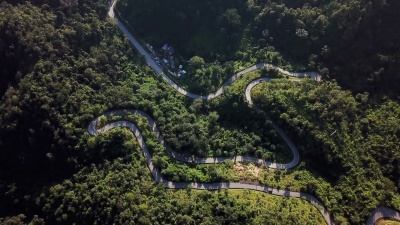 森林中蜿蜒道路和汽车驾驶的鸟瞰，安全驾驶概念