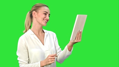 积极的女商人在Skype上与合作伙伴在绿屏上的平板电脑上交谈，Chroma键
