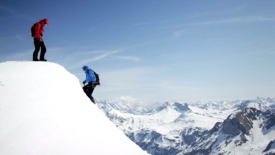 登山者互相帮助到达白雪覆盖的山峰
