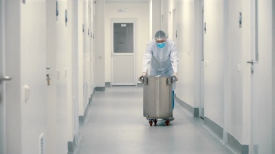 穿着防护服的工人推着桶穿过实验室的走廊
