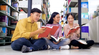 一群年轻的亚洲学生在大学图书馆读书和做研究，学习教育和学校观念