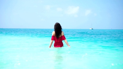 年轻的美女在碧绿的海水中玩得很开心。快乐的女孩享受她的热带假期异国情调的岛屿