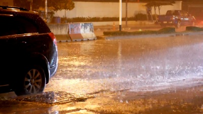 亚洲夜间热带降雨量。汽车在大雨中站立和行驶。泰国