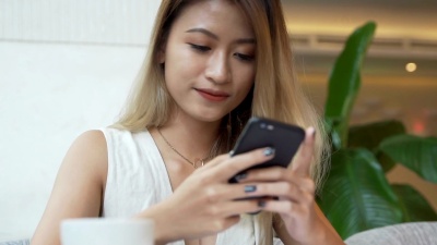 女孩正在考虑在智能手机应用程序上给朋友的回复中写些什么