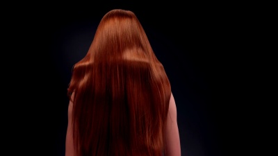 美丽的红发女人甩着她的长发