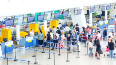 机场旅客人群在柜台大厅办理登机手续延时