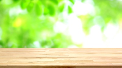 木质桌面上模糊移动的绿叶背景