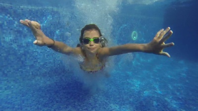 女孩在游泳池里在水下游泳