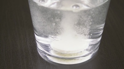 片剂在水缓慢运动的玻璃杯中溶解