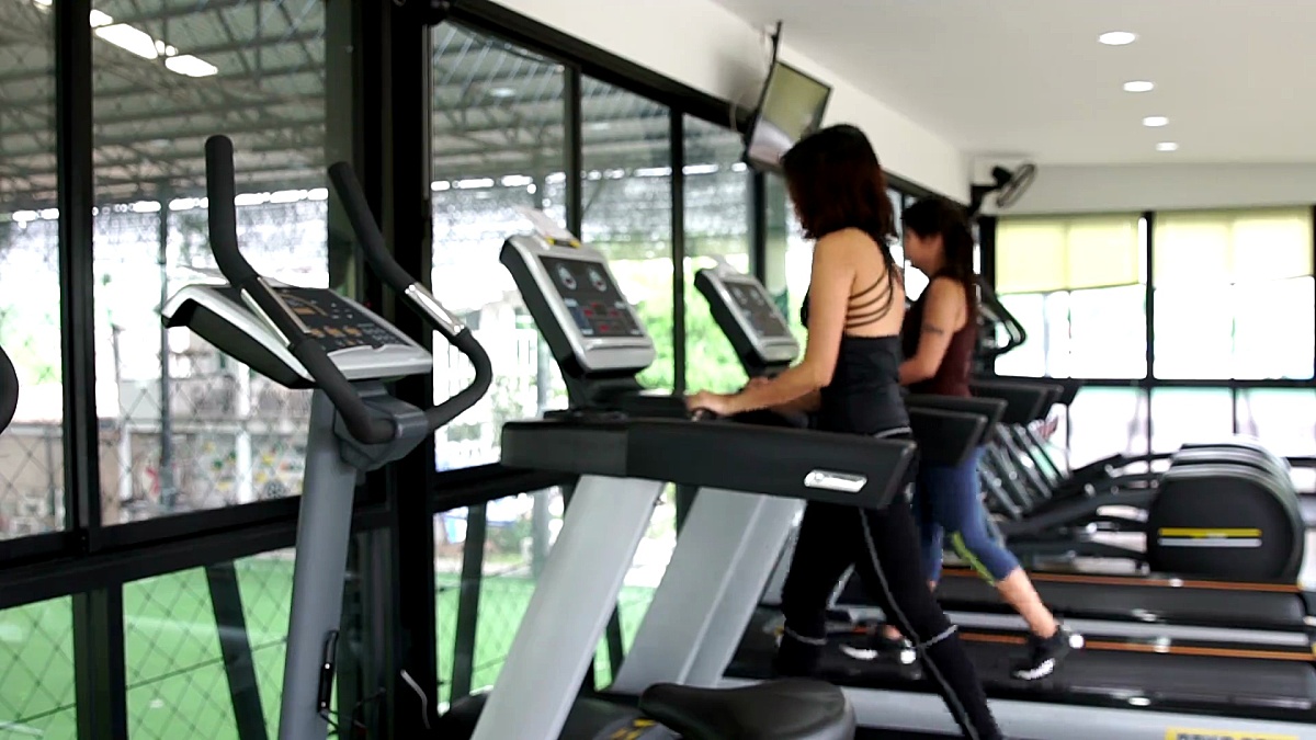 模糊亚洲妇女走在跑步机健身房锻炼