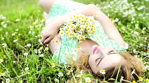 女孩在大自然中休息。美丽的女孩躺在田野上