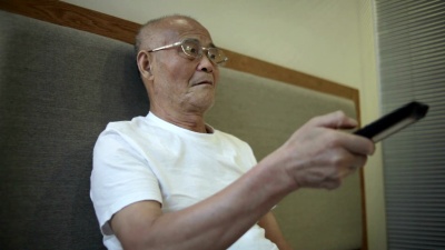 亚裔老人在室内看电视