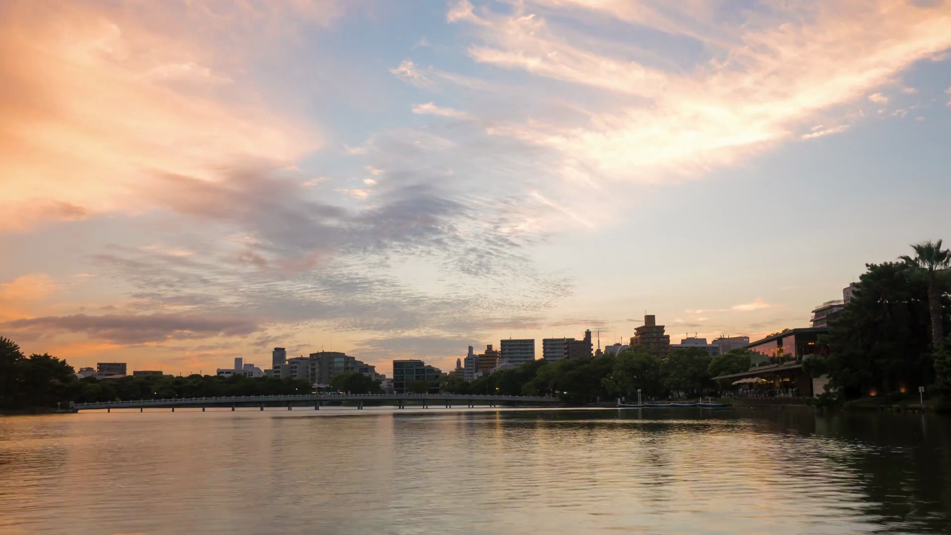 日落时反射在波涛汹涌的湖面上的云景的延时摄影