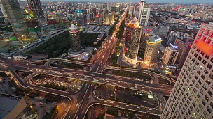 T/L WS HA PAN繁忙道路交叉口和城市天际线鸟瞰，黄昏到夜间过渡/中国北京