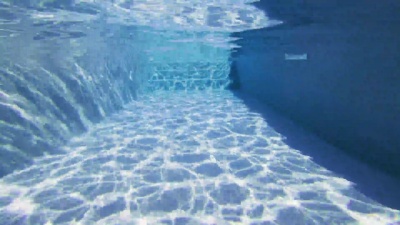 男人在游泳池里游泳的观点 夏天放松